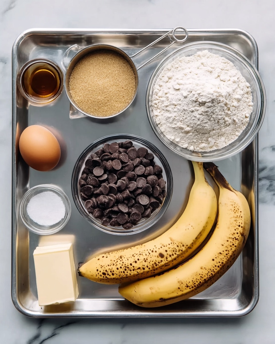 The image shows a metal tray on a white marbled surface holding several baking ingredients neatly arranged. There are two ripe bananas with brown spots in the center right, a small bowl of dark chocolate chips to the top right, and a bowl of white flour above the bananas. On the top left is a cup filled with light brown sugar, next to it a stick of butter is partially visible on the far left edge. Below the brown sugar is a small glass bowl with salt, and next to it is a small glass bowl of vanilla extract. An egg is placed on the bottom left corner of the tray. The colors range from yellow and brown of the bananas to white of the flour and salt, with the dark brown of the chocolate chips and light brown of the sugar standing out. The surface has a clean, simple look. photo taken with an iphone --ar 4:5 --v 7