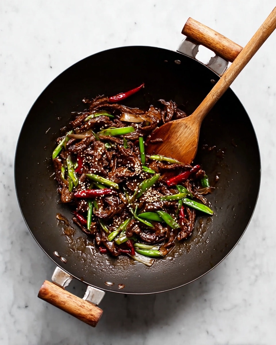 A black wok with wooden handles holds a stir-fry dish. The dish has thin dark brown strips coated in shiny sauce all over, mixed with bright green sliced onions and whole red chili peppers scattered on top. Small white sesame seeds are sprinkled throughout the dish, adding texture. A wooden spatula rests inside the wok, angled slightly to the right. The wok is placed on a white marbled surface. photo taken with an iphone --ar 4:5 --v 7
