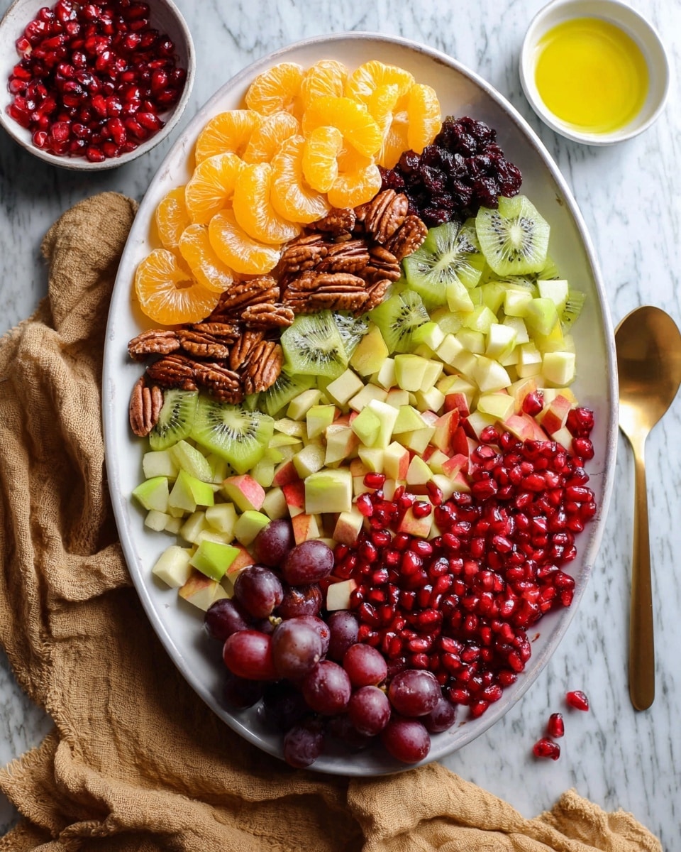 A large white oval plate holds a colorful fruit and nut salad arranged in neat sections; at the top left, bright orange mandarin slices form the first layer, next to shiny dark dried cranberries, then thinly sliced green kiwi on the right side. Below the kiwi, there are whole pecans forming a rough line that continues across to the left, meeting diced light green pear pieces. In the center, juicy red pomegranate seeds create a bright mound overlapping some red apple cubes on the right and halved red grapes with a glossy finish on the bottom left. Around the plate are small white bowls, one holding more bright yellow olive oil and the other filled with extra red pomegranate seeds. The plate rests on a white marbled textured surface, with a beige cloth and a gold spoon nearby. photo taken with an iphone --ar 4:5 --v 7