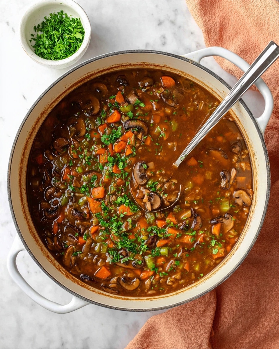A large white pot filled with a thick stew that has visible layers of soft brown mushroom slices, bright orange carrot cubes, and small pieces of celery mixed in a rich, dark brown broth. The stew is sprinkled with chopped green herbs on top. A silver ladle with a long handle is resting inside the pot, partially submerged in the stew. The pot is placed on a white marbled surface with a small white bowl of finely chopped green herbs nearby, and a soft peach-colored cloth is folded next to the pot. photo taken with an iphone --ar 4:5 --v 7