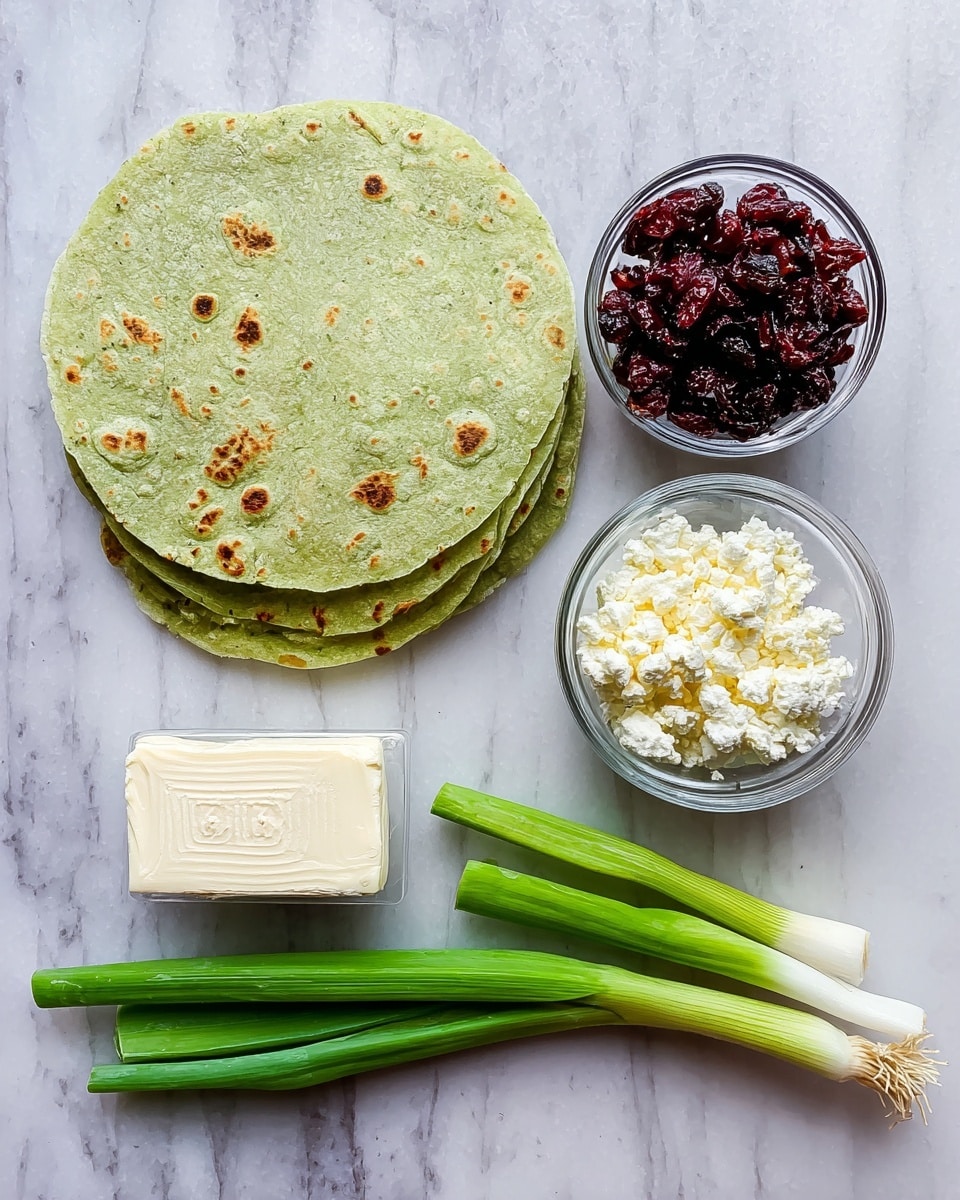 The image shows a top view of cooking ingredients arranged neatly on a white marbled surface. On the left side, there are three green tortillas stacked, showing slight brown spots and texture typical of tortillas. To the right of the tortillas, there are two small clear glass bowls stacked vertically— the top bowl is filled with dark red dried cranberries, and the bottom bowl contains crumbly white cheese. Below the bowls is a rectangular silver package of cream cheese with visible text about measuring and refrigeration. To the far right, three green onions with white bulbs and green stalks lie diagonally. The overall scene is clean and organized, with natural lighting and sharp details. Photo taken with an iphone --ar 4:5 --v 7