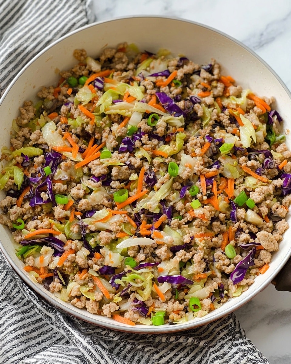 The image shows a white frying pan full of cooked minced meat mixed with small pieces of vegetables. The dish has light brown minced meat as the main filling, scattered with thin orange carrot sticks, chopped green onions, and bits of purple and white cabbage, all mixed evenly. The mixture looks soft and crumbly with a slightly moist texture, and the pan rests on a white marbled surface with a striped cloth in the background. photo taken with an iphone --ar 4:5 --v 7