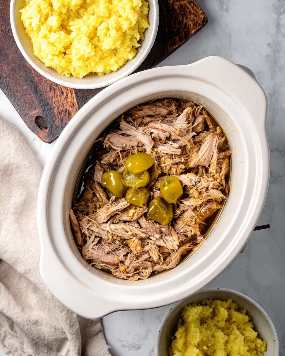 The image shows a white slow cooker filled with shredded light brown meat and several whole yellow-green peppers scattered on top, sitting on a white marbled surface. Above the slow cooker, there is a round bowl filled with mashed yellow food that has a slightly chunky texture. Below the slow cooker, another white bowl holds a similar mashed yellow food. To the left, a soft beige cloth is visible and in the top left corner, a dark wooden cutting board adds contrast to the scene. Photo taken with an iphone --ar 4:5 --v 7