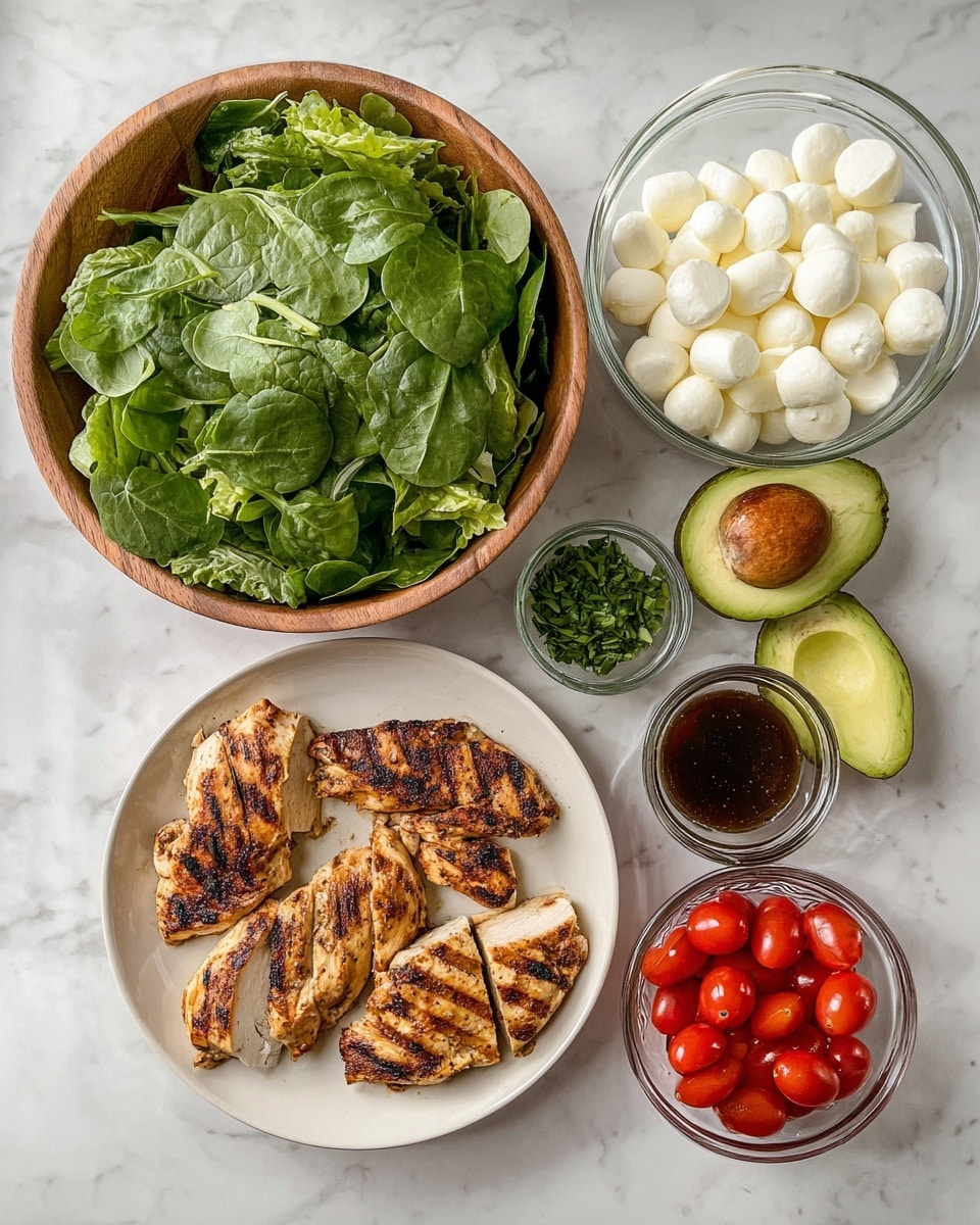 A wooden bowl full of fresh green mixed salad leaves, including spinach and lettuce, sits in the lower left part of the image. To its right, a white plate holds five grilled chicken pieces with brown char marks, each piece sliced across the top. Above the plate is half an avocado with the pit inside, and next to it a small clear bowl with chopped green herbs. Above the salad bowl is a clear glass bowl filled with small white mozzarella balls, and to the left of it is a small clear glass container with a dark brown dressing. In the lower right corner, a small clear bowl holds red grape tomatoes, some halved. All items are placed on a white marbled surface. Photo taken with an iphone --ar 4:5 --v 7