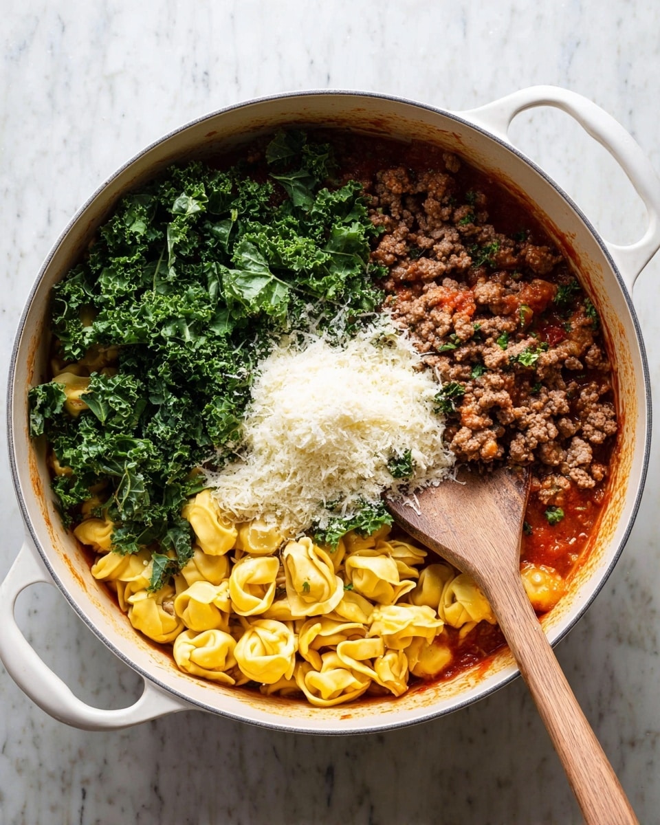 A white pot filled with four main layers: at the bottom, yellow tortellini pasta resting in red sauce, above it on the right side, cooked brown ground meat, on the left side, fresh dark green chopped kale, and in the center, a mound of finely grated white cheese. A wooden spoon rests inside the pot, touching the bottom right side. The pot is set on a white marbled surface. Photo taken with an iphone --ar 4:5 --v 7