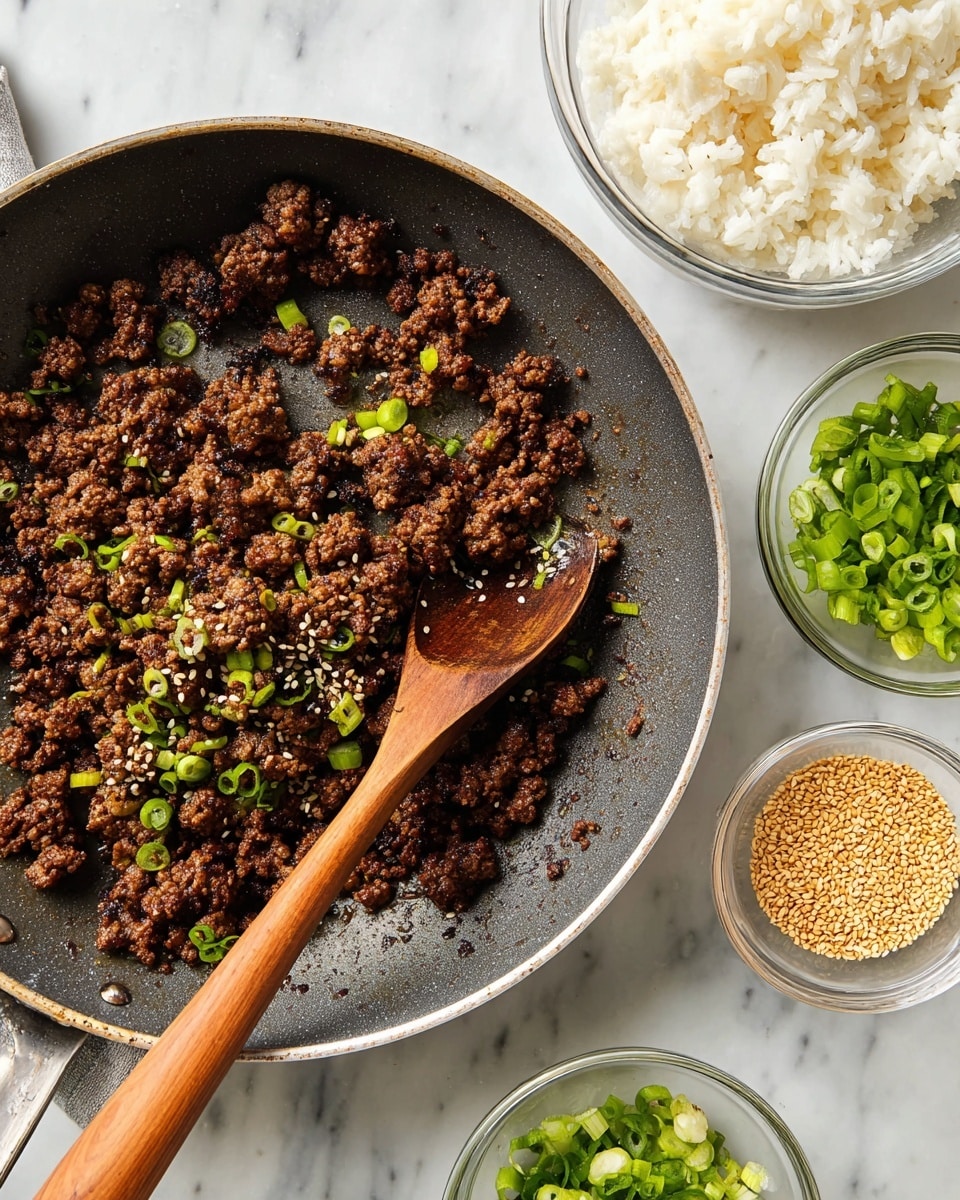 In the image, there is a close-up of a frying pan filled with cooked ground meat that is dark brown and slightly crispy, sprinkled with light green chopped scallions and small sesame seeds. A wooden spoon with a light brown handle rests in the pan, partly stirring the meat. Around the pan, there are three small clear glass bowls: one with white cooked rice grains, one with more chopped green scallions, and one with golden sesame seeds. The items are placed on a white marbled surface with a clean and bright look. photo taken with an iphone --ar 4:5 --v 7