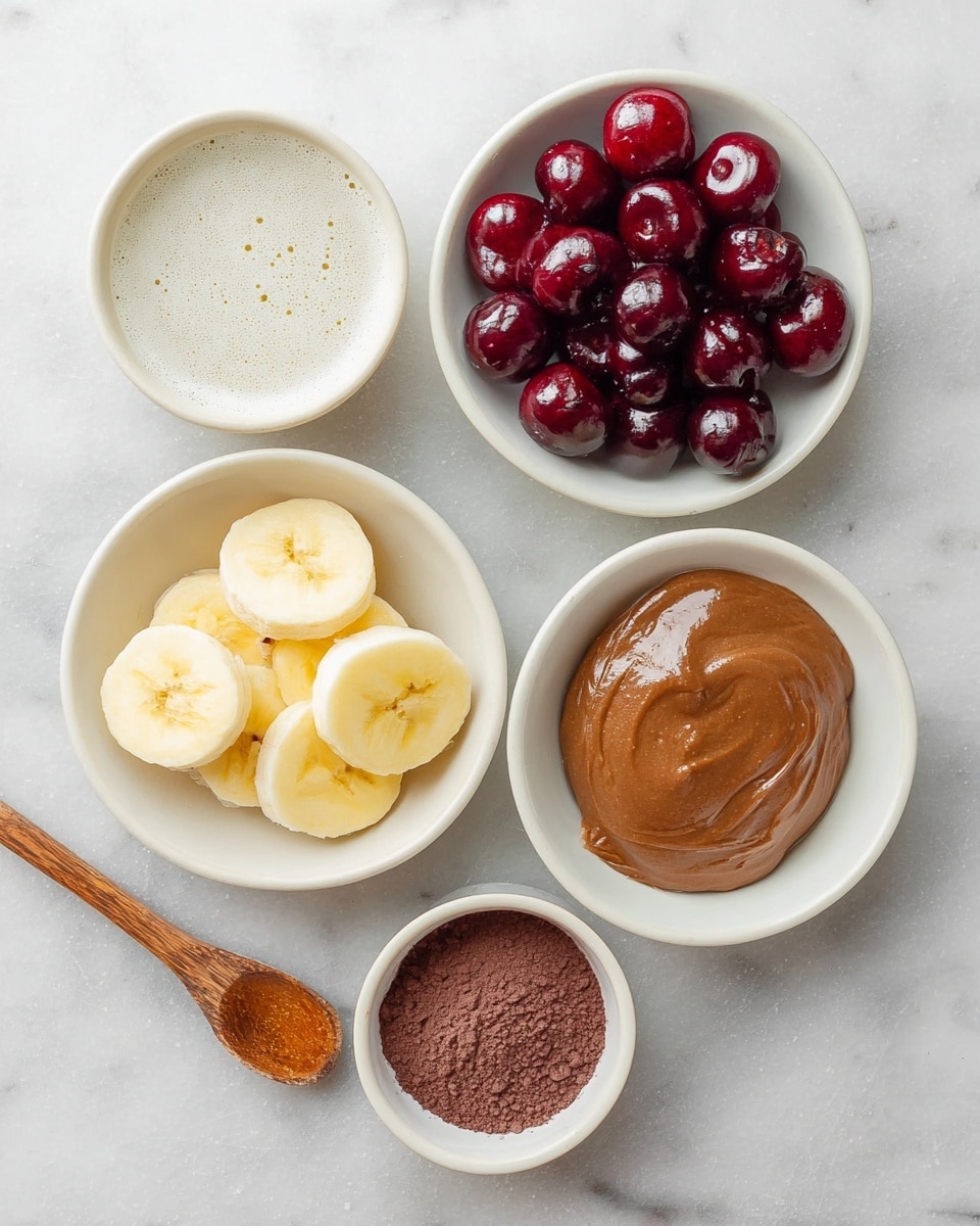The image shows five small white bowls placed on a white marbled surface. The top left bowl contains a light white liquid with small bubbles on the surface. The top right bowl is filled with shiny dark red cherries. Below the cherries, a bowl holds a smooth, shiny light brown spread. To the left of this spread is a bowl with round slices of yellow banana stacked loosely. The bottom left bowl contains fine dark brown powder with a small wooden spoon resting inside. photo taken with an iphone --ar 4:5 --v 7
