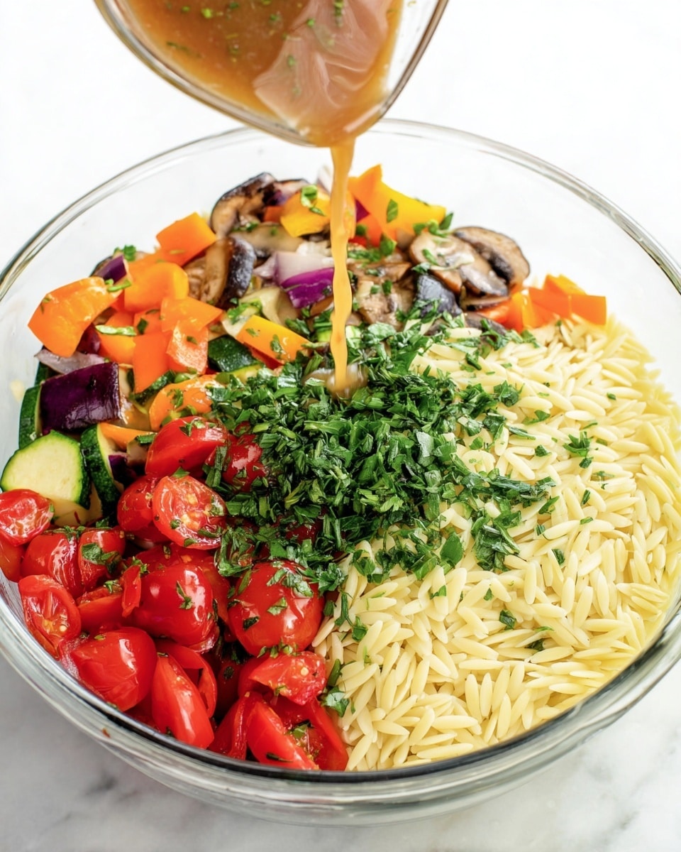 The image shows a clear glass bowl filled with four distinct layers of food. On the left side, there is a colorful mix of roasted vegetables including orange bell peppers, red cherry tomatoes, purple onions, zucchini slices, and mushrooms. On the right side, a large portion of cooked orzo pasta in a pale yellow color fills the bowl. Between these two layers, finely chopped fresh green herbs like basil, chives, and parsley sit atop the vegetables and pasta. A light brown dressing is being poured from a glass jug into the center of the bowl, over the herbs. The bowl is placed on a white marbled texture. Photo taken with an iphone --ar 4:5 --v 7