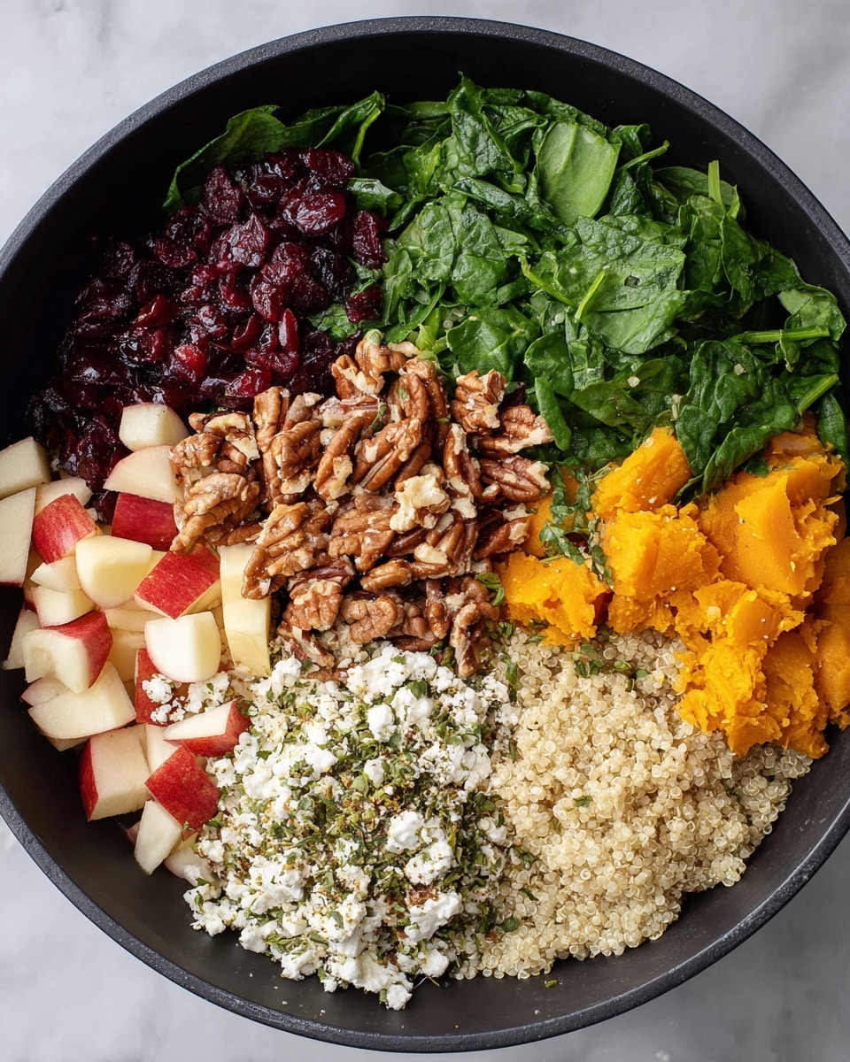 A black bowl sits on a white marbled surface, filled with six distinct layers arranged in sections. Starting from the top left, there are dark red dried cranberries with a slight shine, next to bright green chopped spinach leaves with a fresh texture. Moving clockwise, there is a pile of chopped brown pecans with rough texture, beside a section of bright orange cooked butternut squash, slightly mashed with some texture. Below that is a layer of white crumbled feta cheese sprinkled with a mix of herbs and spices in green and brown shades. Finally, at the bottom left, small diced pieces of red apple with white flesh and a mound of light beige cooked quinoa with a soft, grainy texture complete the arrangement. photo taken with an iphone --ar 4:5 --v 7