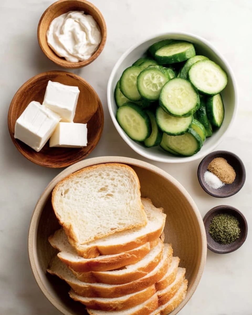 The image shows several food items arranged on a white marbled surface, including a large round bowl filled with neatly sliced white bread with a soft texture and golden crust, placed in the lower center. Above the bread, there is a white bowl overflowing with evenly cut cucumber slices showing green skin and pale green insides. To the left of the cucumbers, a small wooden bowl holds smooth white sauce, and below that, another small wooden bowl contains several white, soft blocks that look like cheese. On the right side of the cucumbers, a small dark round dish holds four different spices arranged in equal sections: black pepper, salt, green herb flakes, and a tan powder. The overall scene is clean and simple with no extra decorations, focusing on fresh ingredients. Photo taken with an iphone --ar 4:5 --v 7