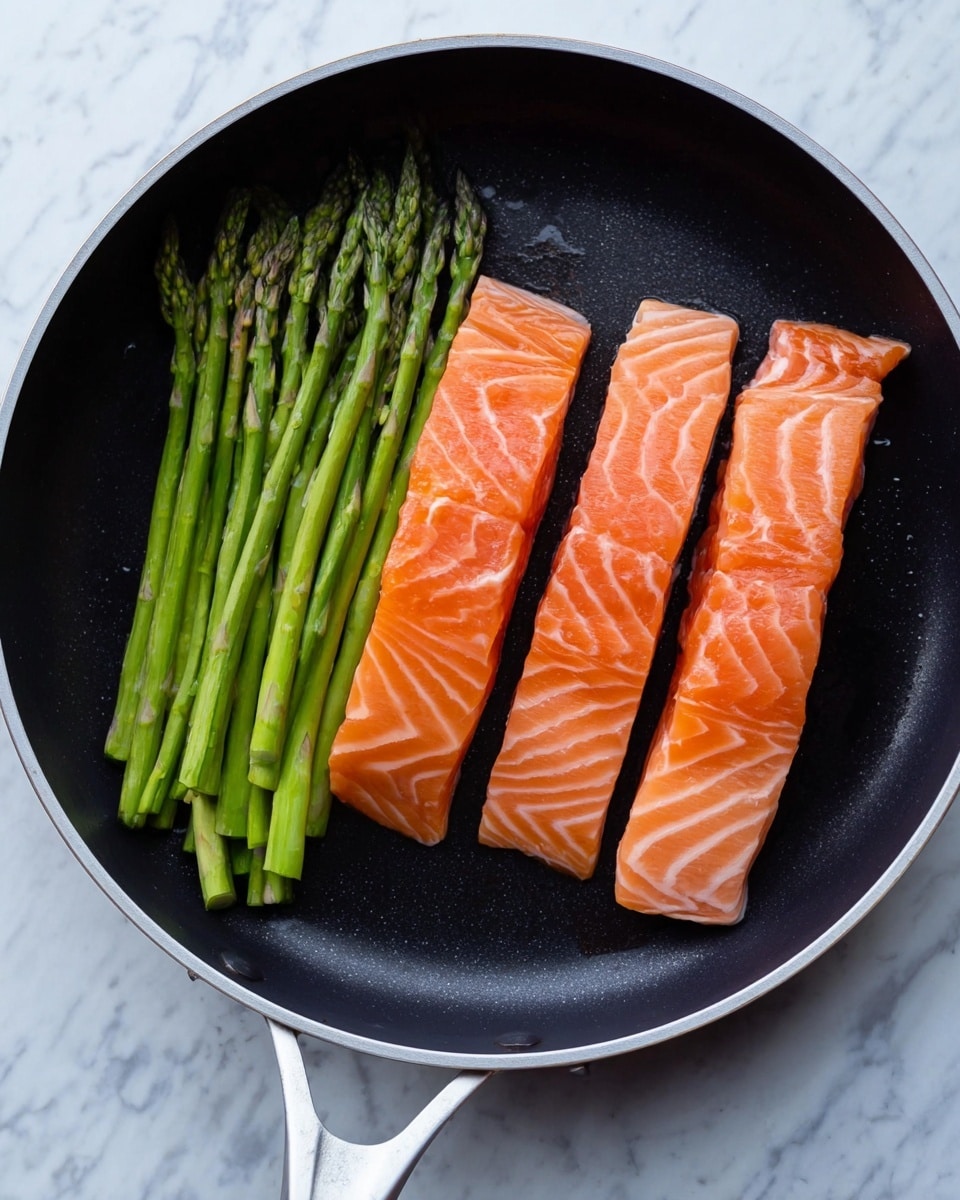 A black pan with a white handle sits on a white marbled surface. Inside the pan, there are three long, thick pieces of raw salmon arranged vertically on the right side with bright orange color and light white lines showing the fish texture. On the left side of the pan, there is a bundle of green asparagus stalks, fresh and firm, placed neatly with the tips facing up. The pan’s inner surface is smooth and dark, contrasting with the bright colors of the salmon and asparagus. photo taken with an iphone --ar 4:5 --v 7