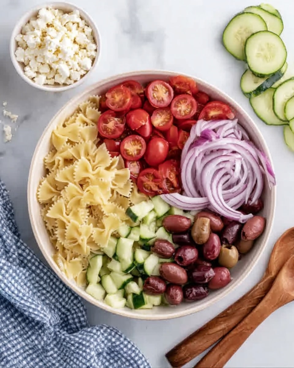A white bowl sits on a white marbled surface filled with four main layers. The bottom layer is light yellow pasta shaped like small bows, filling the whole bowl. On top, the bowl is divided into four sections: bright red cherry tomatoes cut in half on the bottom left, light green cucumber pieces roughly chopped on the top left, dark brown sliced olives in the top right, and light purple thin onion rings on the bottom right. Around the bowl, there is a small white bowl filled with white cheese curds on the top left, a wooden spoon and fork on the right, a few cucumber slices on the top right, and a blue and white checked cloth on the bottom left. The picture is taken with an iphone --ar 4:5 --v 7