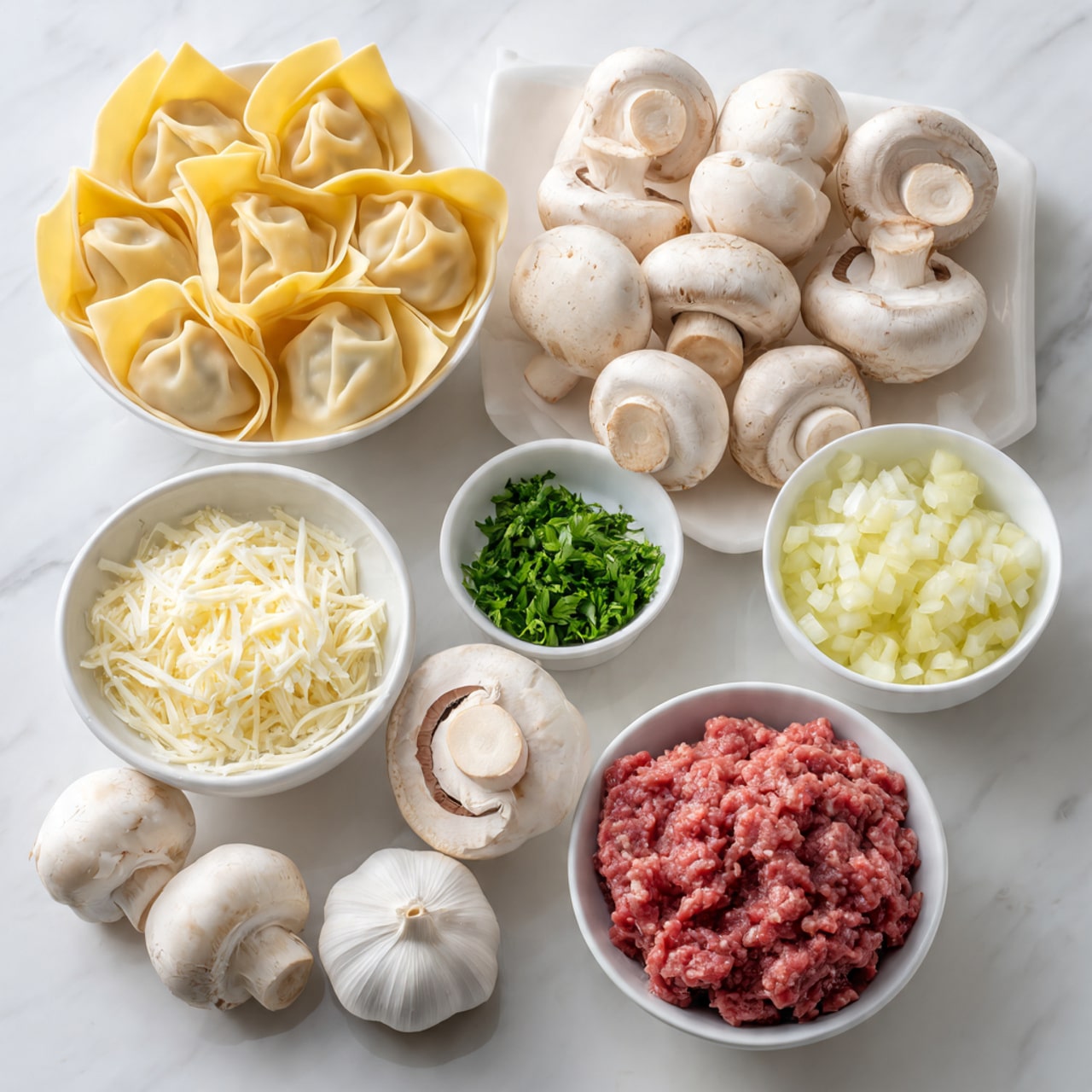 The image shows various cooking ingredients arranged on a white marbled surface. On the left, there is a white bowl filled with folded pale yellow wonton wrappers stacked unevenly. Near the center, there are many whole white mushrooms, some with their caps facing up and some lying on their sides, showing their white stems. At the bottom center, a small white bowl holds finely shredded white cheese. At the top center, a small white bowl contains chopped green herbs. To the right of the mushrooms are four whole garlic cloves and a large whole garlic bulb. At the far right, two white bowls hold finely chopped onions, one bowl of yellow onion and one empty. Near the bottom right, a white bowl is full of raw, bright red ground meat with a slightly coarse texture. The scene is well lit, and all items are neatly arranged on the white marbled background photo taken with an iphone --ar 4:5 --v 7