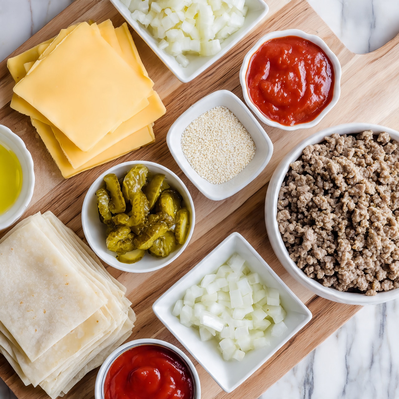 The image shows a wooden board on a white marbled surface with ingredients arranged neatly. In the top left corner are three slices of yellow American cheese stacked. To the right, in a white bowl, are small white sesame seeds. Next to it in a red bowl are diced green pickles, and beside the pickles is a white bowl with diced white onions. There is a white bowl holding a mix of white mayo, yellow mustard, green relish, red ketchup, and clear vinegar as a special sauce. Below these sauces is a white bowl filled with cooked brown ground beef mixed with garlic powder, salt, and pepper. In the bottom left corner, there is a stack of square, translucent egg roll wrappers. A small white dish holds light yellow oil near the center. Everything is displayed on a wooden board with a white marbled background. Photo taken with an iphone --ar 4:5 --v 7