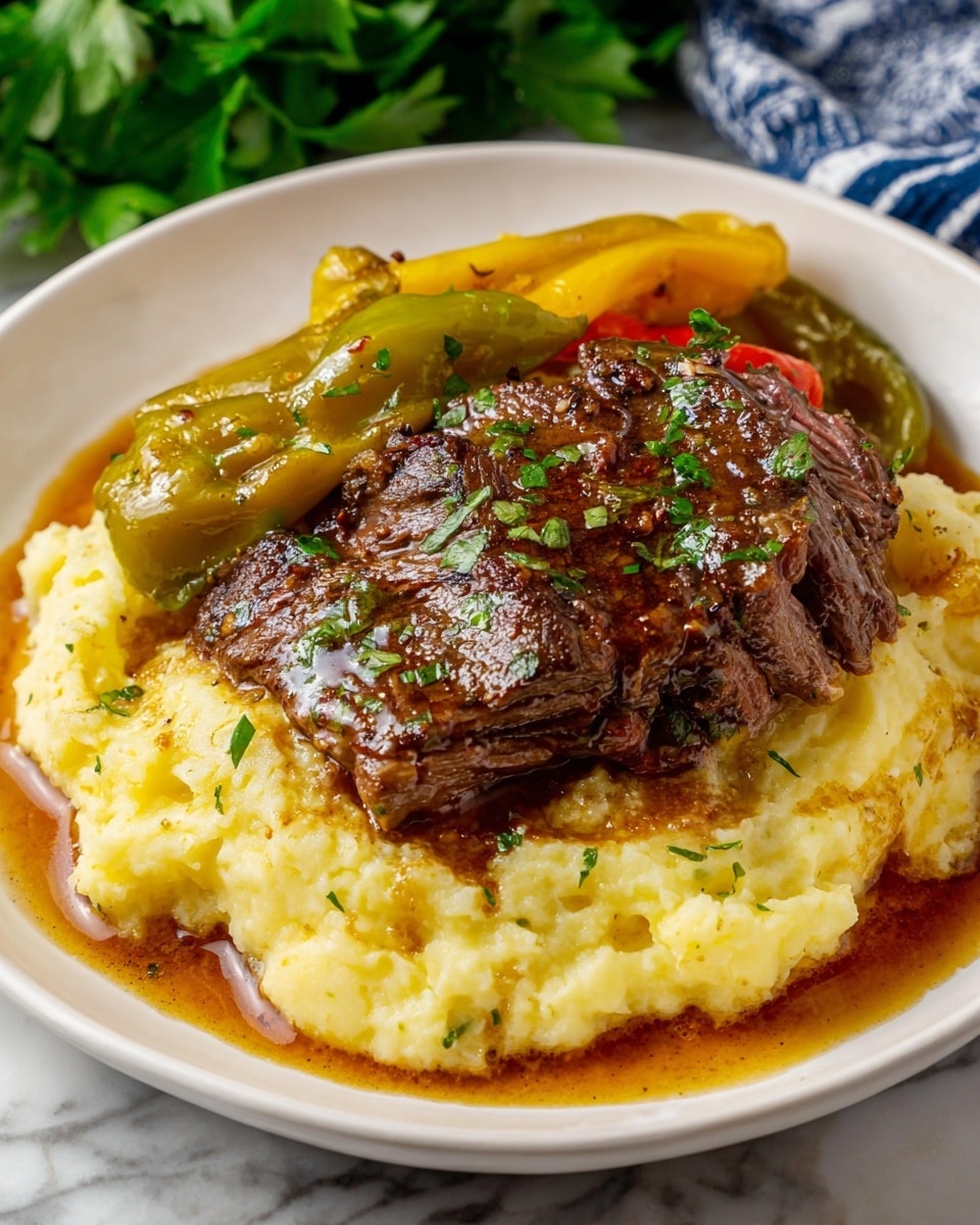 A white plate holds a dish with three main layers; the bottom layer is creamy, light yellow mashed potatoes with a soft and smooth texture. On top of that lies a thick, glossy brown steak with a slightly charred and juicy surface sprinkled with small green herb pieces. Surrounding the steak on the mashed potatoes are several shiny, yellow-green roasted peppers with skins that look tender and slightly wrinkled. The plate sits on a white marbled surface with some oil and sauce dripping around the food, and green parsley leaves are visible in the background. photo taken with an iphone --ar 4:5 --v 7