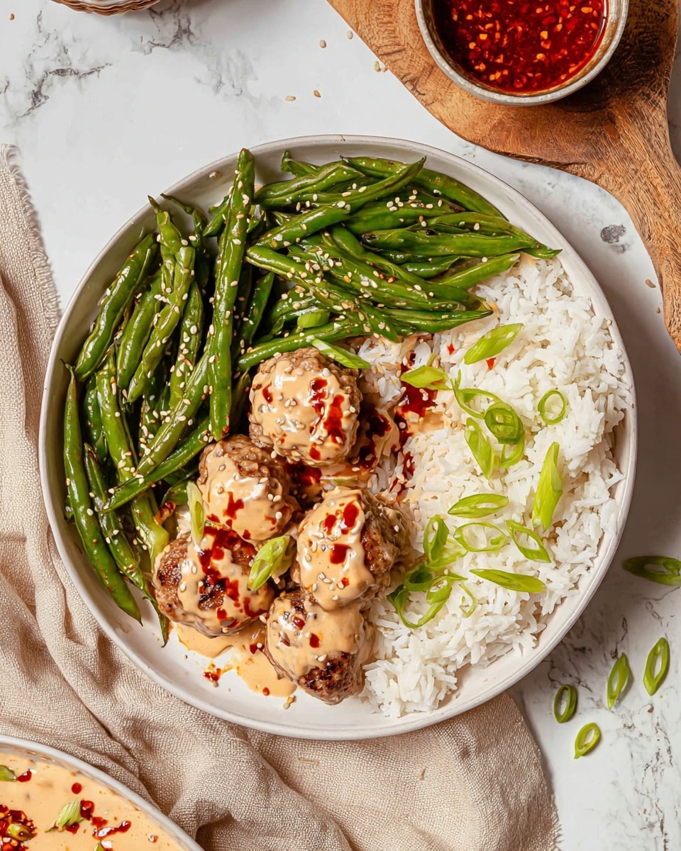 The dish shows multiple small, round dark brown meatballs placed on a bed of loose white rice. Each meatball is topped with a thick light beige sauce drizzled unevenly, with a dark red chili oil streak running across it, sprinkled with white sesame seeds. Bright green thinly sliced green onions are scattered on and around the meatballs and rice, adding a fresh contrast. The ingredients are all in a white bowl with a white marbled surface beneath. photo taken with an iphone --ar 4:5 --v 7