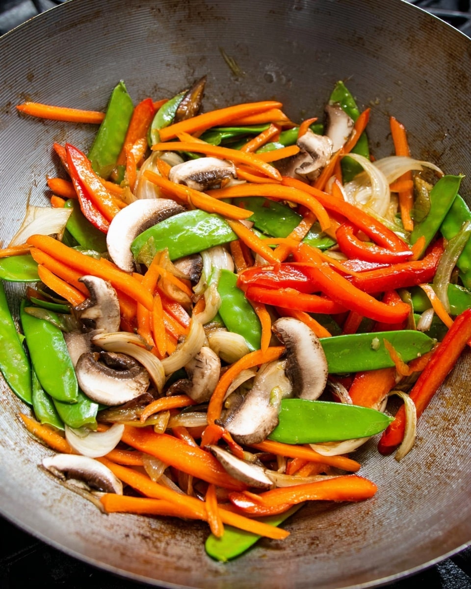 The image shows a metal wok filled with stir-fried vegetables. The bottom layer has bright green snow peas spread across. On top of that is a mix of orange carrot strips and long red bell pepper slices scattered evenly. There are white onion strips mixed in, adding light color and texture. Sliced brown mushrooms with white stems are placed randomly, some showing their curved caps. The metal wok has some browned cooking marks visible, creating a contrast with the colorful vegetables inside. The overall look is fresh and vibrant with different shapes and colors of the vegetables clearly seen photo taken with an iphone --ar 4:5 --v 7