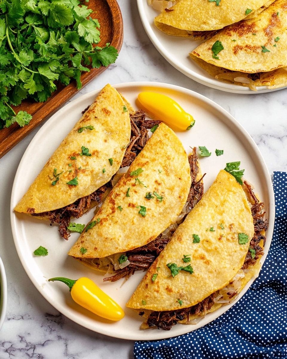 The image shows a white plate with three folded tacos arranged side by side. Each taco has a golden brown tortilla that looks warm and slightly crispy, sprinkled with small green cilantro pieces on top. Inside the tortillas is a layer of dark, shredded meat mixed with bits of lightly cooked onions visible at the edges. On the left and right edges of the plate, there is a bright yellow pepper adding a pop of color. The plate is set on a white marbled surface, with a bunch of fresh green cilantro on a wooden tray in the upper left corner and part of another plate with similar tacos visible in the top right. A blue cloth with white polka dots is partially visible at the bottom left corner. Photo taken with an iphone --ar 4:5 --v 7
