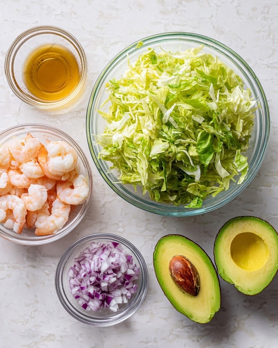 A clear glass bowl filled with a large pile of shredded green lettuce sits on a white marbled surface. To the right of the lettuce, halved avocado with bright green and pale yellow flesh, one half showing the brown pit, is placed near a small clear glass bowl of finely chopped purple and white onion. Below the avocado, a small clear glass bowl contains several pink and white cooked shrimp. Above the avocado, there is a small clear glass bowl with golden-brown liquid dressing. The setting is bright and clean with a white marbled background, showing all ingredients separately. photo taken with an iphone --ar 4:5 --v 7