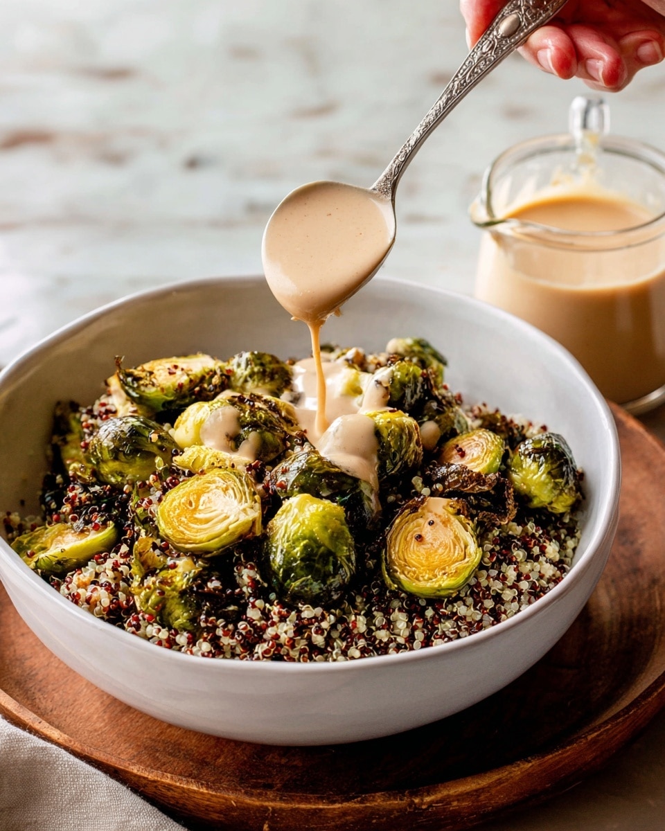 A white bowl filled with two layers, the bottom layer is a mix of light and dark quinoa with small round grains, and on top, a layer of golden brown roasted Brussels sprouts, some cut in half showing their soft texture inside, with slightly charred edges. A woman's hand holds a spoon above the bowl, pouring a smooth, light beige sauce onto the Brussels sprouts, with some of the sauce dripping down. To the side on a white marbled surface is a glass measuring cup filled with the same sauce. The scene is bright and cozy, with a wooden base under the bowl and soft natural light. photo taken with an iphone --ar 4:5 --v 7