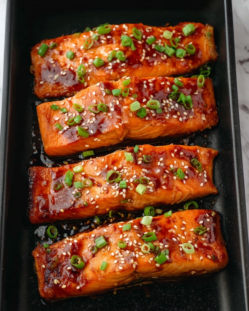 Four rectangular salmon fillets with a shiny orange glaze are placed on a black tray. Each fillet is covered with small white sesame seeds and scattered with chopped green onions. The glaze gives the salmon a slightly sticky look, with darker caramelized spots on the surface. The black tray contrasts with the bright colors of the salmon and toppings, and the background is changed to a white marbled texture. photo taken with an iphone --ar 4:5 --v 7