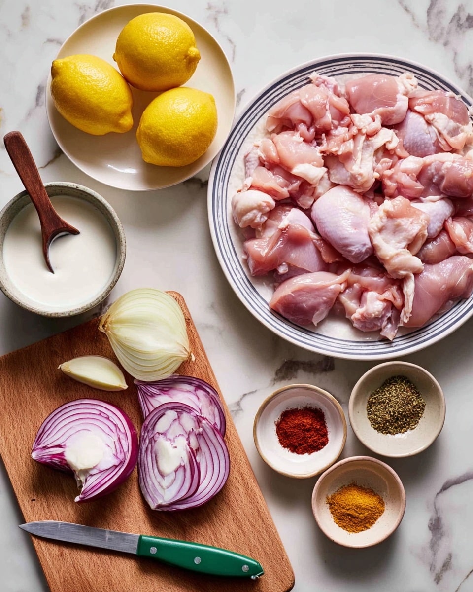 The image shows a white plate filled with many pieces of raw, pink chicken, positioned in the upper right. To the left of the plate, there is a small white bowl with white sauce and a wooden spoon inside. Above this bowl, a white plate holds two yellow lemons. Below the lemon plate, on a wooden cutting board with a green-handled knife, there are sliced pieces of red onion along with whole and halved onions around it. To the right of the board, there is a small white bowl with four piles of red, brown, and yellow spices. The whole scene is set on a white marbled surface. photo taken with an iphone --ar 4:5 --v 7