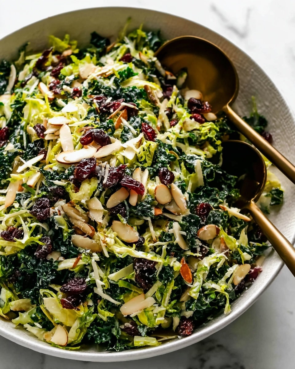 A large white bowl filled with a colorful salad showing several layers: the main layer consists of shredded dark green kale and light green shredded Brussels sprouts with some texture, scattered dark red dried cranberries add contrast, mixed with small pieces of light brown chopped almonds, and thin pale yellow shredded cheese sprinkled evenly across. Two bronze spoons rest inside the bowl, partially covered by the salad. The bowl sits on a white marbled surface. photo taken with an iphone --ar 4:5 --v 7