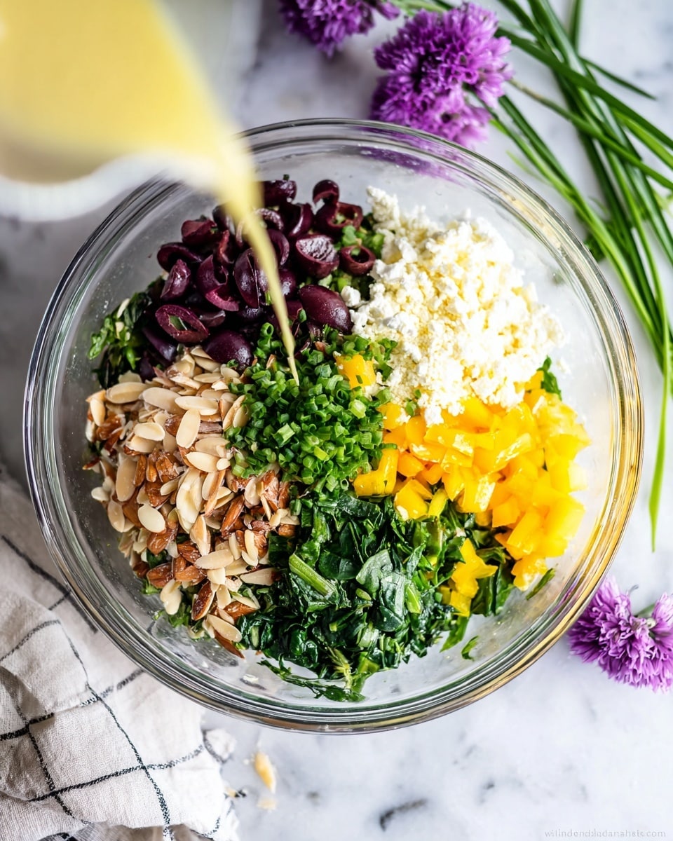 A clear glass bowl is shown from above, placed on a white marbled surface, filled with seven distinct layers of colorful ingredients arranged in sections. Starting from the top, there are dark purple sliced olives, next to a fluffy white layer of crumbly cheese. To the right is finely chopped green chives, followed by a layer of leafy chopped spinach. Below the spinach is bright yellow diced bell pepper. To the left of the pepper is a pile of chopped green herbs, and finally there are toasted slivered almonds and brown pasta or grains near the olives. In the center, a light yellow dressing is poured over the layers, captured mid-stream by a woman's hand. A few purple flowers and a cloth with a checkered pattern are nearby on the white marbled surface. photo taken with an iphone --ar 4:5 --v 7