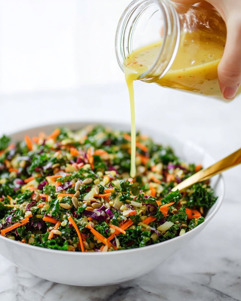 A white bowl filled with a fresh mixed salad showing many small chopped pieces of green kale, orange carrot shreds, purple cabbage, and bits of sunflower seeds. A golden spoon rests on the edge inside the bowl. Above, a woman's hand is pouring a light yellow dressing from a small glass jar onto the salad. The background is a white marbled surface, bright and clean. photo taken with an iphone --ar 4:5 --v 7