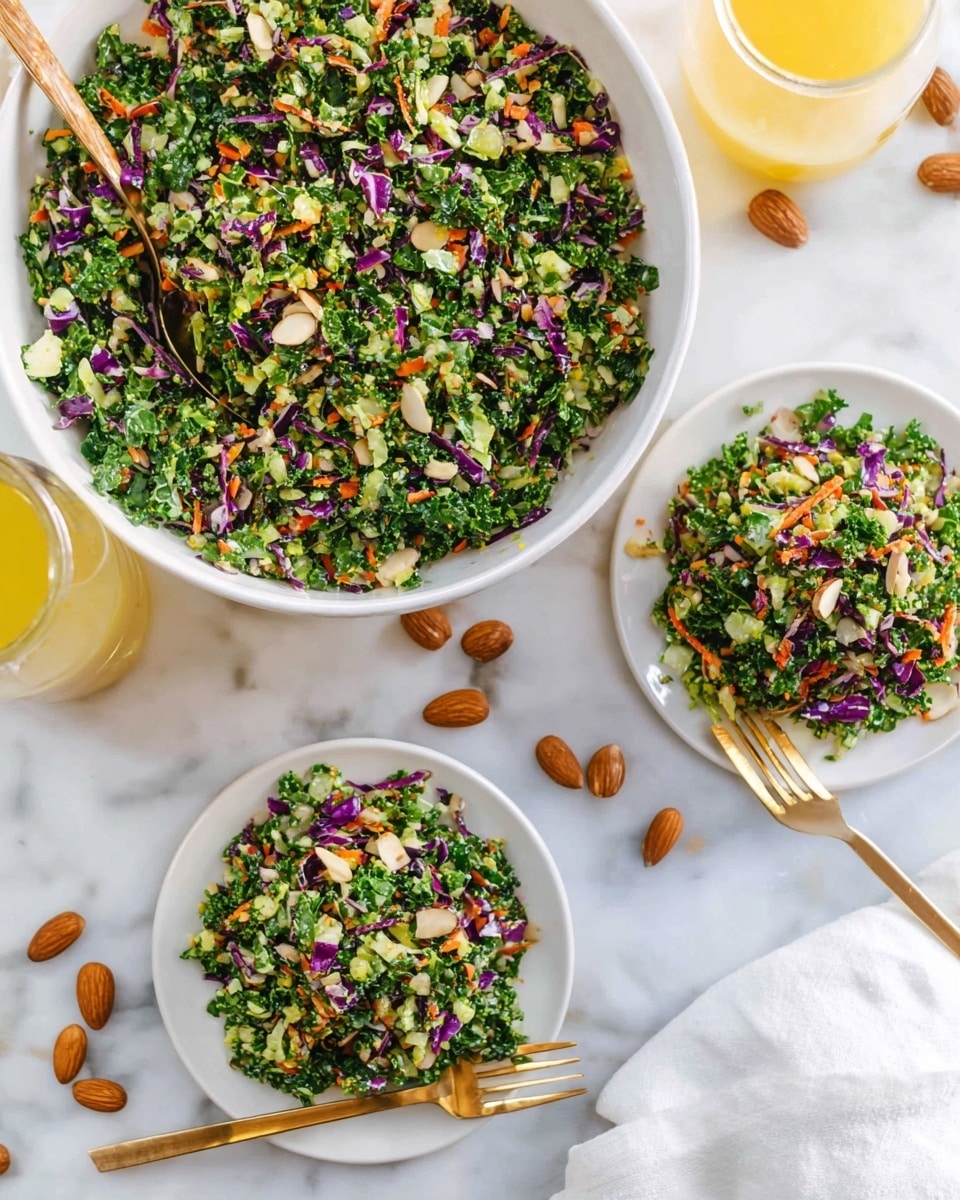 A bright and fresh salad made of finely chopped green kale, green cabbage, purple cabbage, and orange carrot bits fills a large white bowl and two smaller white plates. The chopped vegetables create a colorful mix with green as the main color, sprinkled with flecks of purple and orange. Around the plates and bowl are whole almonds scattered over a white marbled surface. A gold spoon rests inside the large bowl, and another gold fork is on one of the plates. A glass jar with yellow dressing is partially visible on the left edge, and a white cloth napkin is on the right side. The lighting is bright and natural, showing the crisp textures clearly. photo taken with an iphone --ar 4:5 --v 7