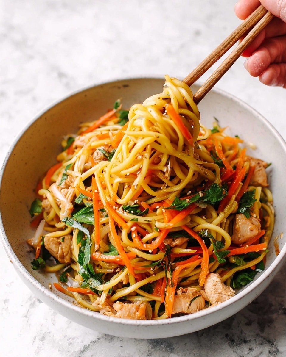 A white bowl filled with cooked yellow noodles mixed with thin orange carrot strips and green leafy herbs, with small pieces of cooked light brown chicken scattered around. A woman's hand holding wooden chopsticks lifts a tangled bunch of noodles and carrots from the bowl. The background and surface have a white marbled texture. photo taken with an iphone --ar 4:5 --v 7