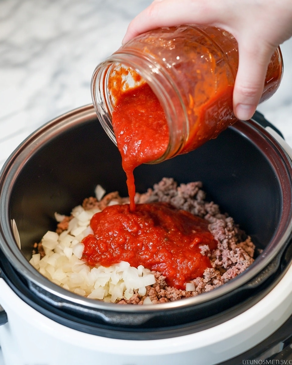 A woman's hand is pouring bright red tomato sauce from a clear jar into a white pot on a kitchen appliance. Inside the pot, there are three visible layers: the bottom layer has brown cooked ground meat, the middle layer has white chopped onions, and the top layer is the red thick tomato sauce being added. The kitchen appliance’s edge is black with a white inner pot, and the background shows a white marbled surface. The photo taken with an iphone --ar 4:5 --v 7
