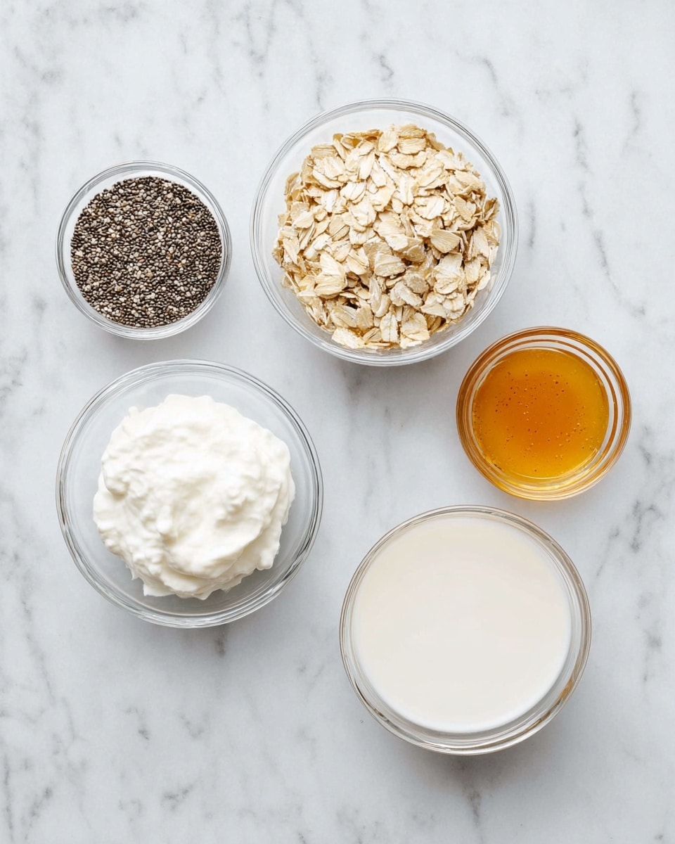 The image shows six clear glass bowls arranged on a white marbled surface. The top left bowl contains small black and white chia seeds, which have a rough, grainy texture. Below it, there is a bowl filled with fluffy, white Greek yogurt, smooth and creamy in texture. At the center is a bowl of flat, light beige rolled oats that look dry and slightly rough. On the top center and right, there are two small bowls, each holding golden brown honey with a thick, sticky look. Finally, the bowl on the bottom right contains smooth white almond milk filling the bowl almost to the top. photo taken with an iphone --ar 4:5 --v 7