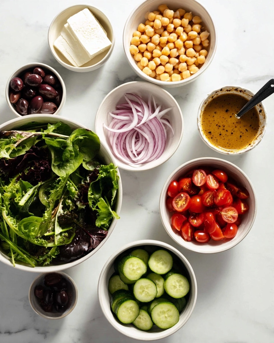 Seven white bowls sit on a white marbled surface, each holding a different fresh ingredient. The largest bowl at the bottom left is filled with a mix of leafy greens, dark and light green in color. Moving clockwise, the next bowl contains whole chickpeas, light beige and round. Above that is a bowl with slices of white cheese stacked neatly. Next to it, a bowl holds thin slices of purple-red onion. To the right, there is a bowl of light brown salad dressing with small black specks and a black spoon inside. Below the dressing, a bowl has sliced green cucumbers arranged in neat circles. At the bottom right, there is a bowl filled with halved red cherry tomatoes. In the center, a smaller bowl contains dark purple olives. Photo taken with an iphone --ar 4:5 --v 7