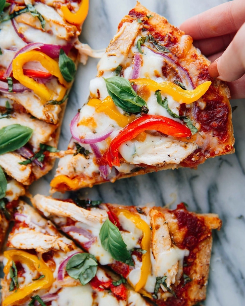This image shows a close-up of a pizza slice being lifted by a woman's hand. The pizza has a golden-brown crust with melted white cheese on top. There are colorful slices of red and yellow bell peppers, red onion, and pieces of grilled light brown chicken layered between the cheese and a red tomato sauce base. Fresh green basil leaves are scattered on the pizza, adding a touch of vibrant green color. The pizza is set on a white marbled surface. Photo taken with an iphone --ar 4:5 --v 7
