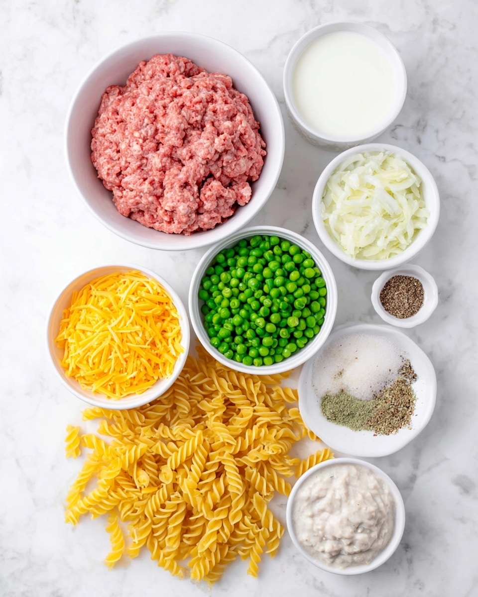 The image shows an overhead view of seven bowls and a pile of uncooked yellow twisted pasta arranged on a white marbled surface. At the top center is a white bowl filled with pink raw ground meat that looks soft and crumbly. Below and around it, there are six other white bowls: one with shredded yellow cheese to the left, one with bright green frozen peas in the middle, one with creamy white sauce speckled with darker bits to the right, one containing chopped white onions, one with white milk, and one with a mix of dry spices including black pepper, garlic powder, and another powder. The yellow twisted pasta is spread loosely at the bottom, occupying the lower part of the image. photo taken with an iphone --ar 4:5 --v 7