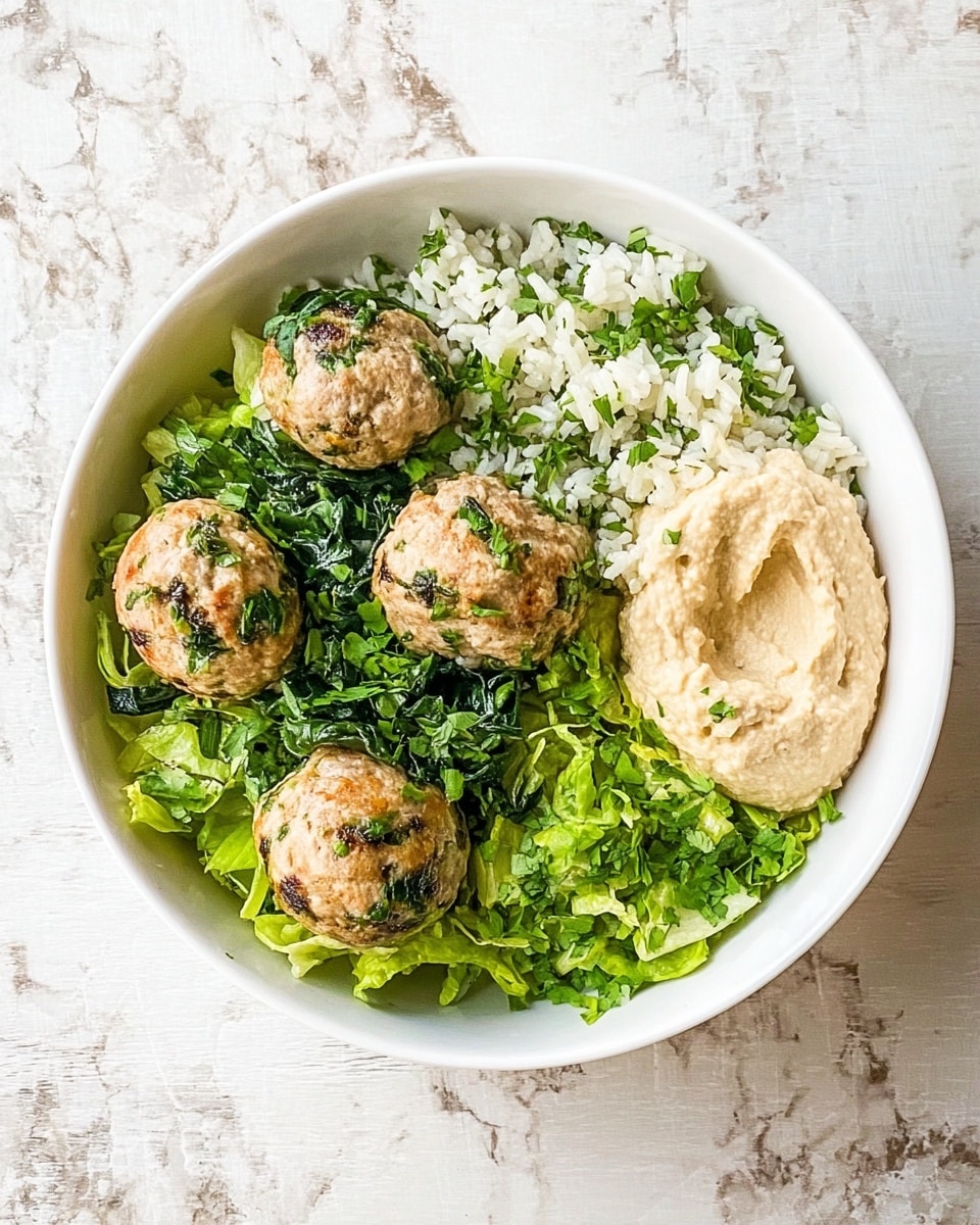 In a white bowl on a white marbled surface, there is a dish with four round, light brown meatballs mixed with green spinach pieces placed on the left side. Next to the meatballs on the right is a large dollop of smooth, light beige hummus. Underneath and slightly around the meatballs and hummus is a bed of chopped bright green lettuce. The top left section of the bowl contains white rice mixed with finely chopped green herbs. The overall look is fresh and colorful with clear separation between each component. photo taken with an iphone --ar 4:5 --v 7