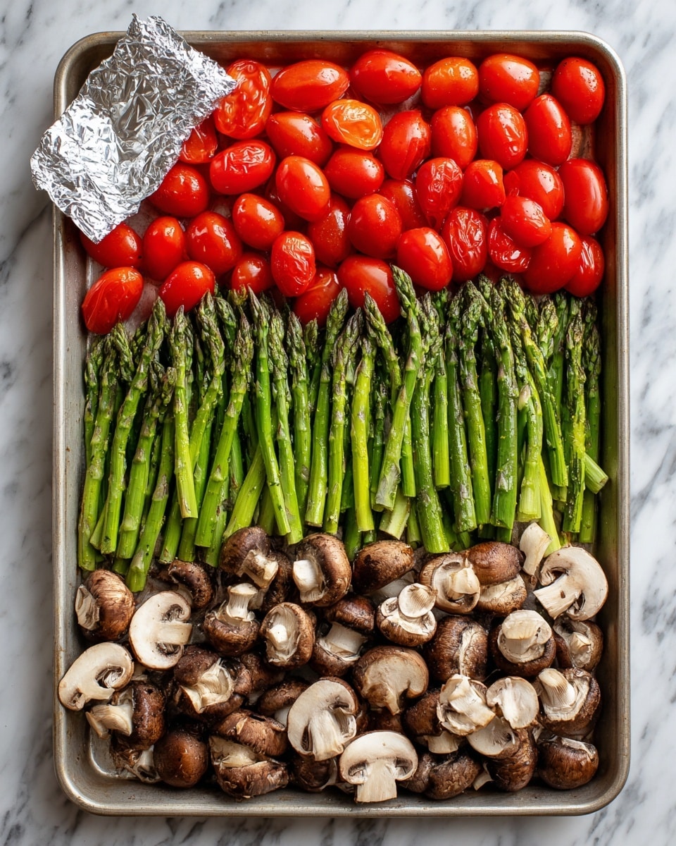 A large baking tray with three main layers of fresh vegetables arranged evenly: the top layer has bright red grape tomatoes grouped close together, the middle layer is filled with vibrant green chopped asparagus spears laid side by side, and the bottom layer contains many sliced brown mushrooms with white undersides facing up. There is one small silver foil packet placed on the top left corner of the tray. The tray is set on a white marbled surface. Photo taken with an iphone --ar 4:5 --v 7