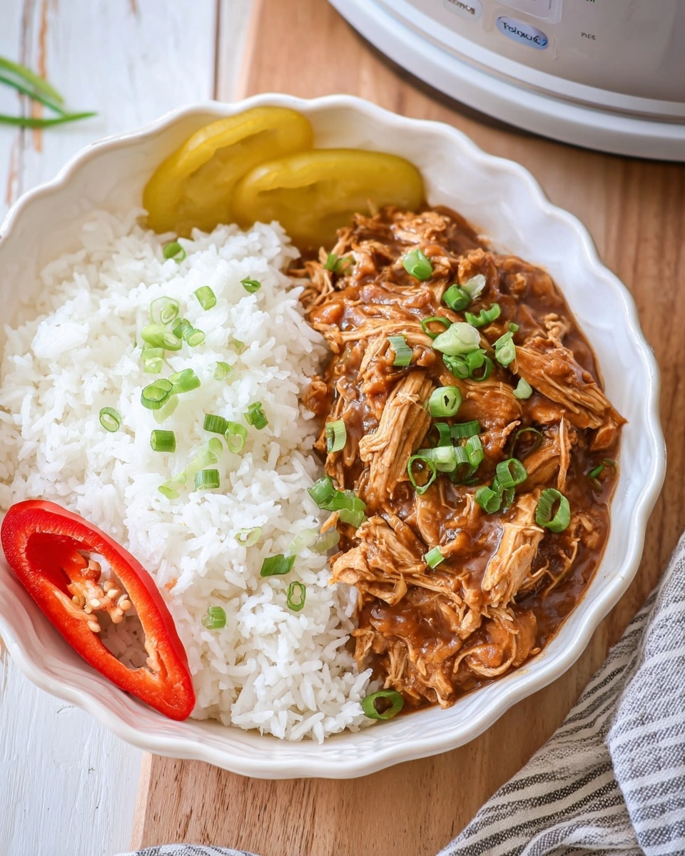 A white scalloped bowl contains two main sections: a large portion of fluffy white rice on the left and a serving of shredded chicken covered with brown sauce on the right. The chicken is garnished with small green chopped scallions scattered on top. On the left side of the bowl, there are two slices of yellow bell pepper and one half of a red chili pepper with visible seeds. The bowl sits on a light wooden surface with a striped cloth partially visible nearby. Photo taken with an iphone --ar 4:5 --v 7
