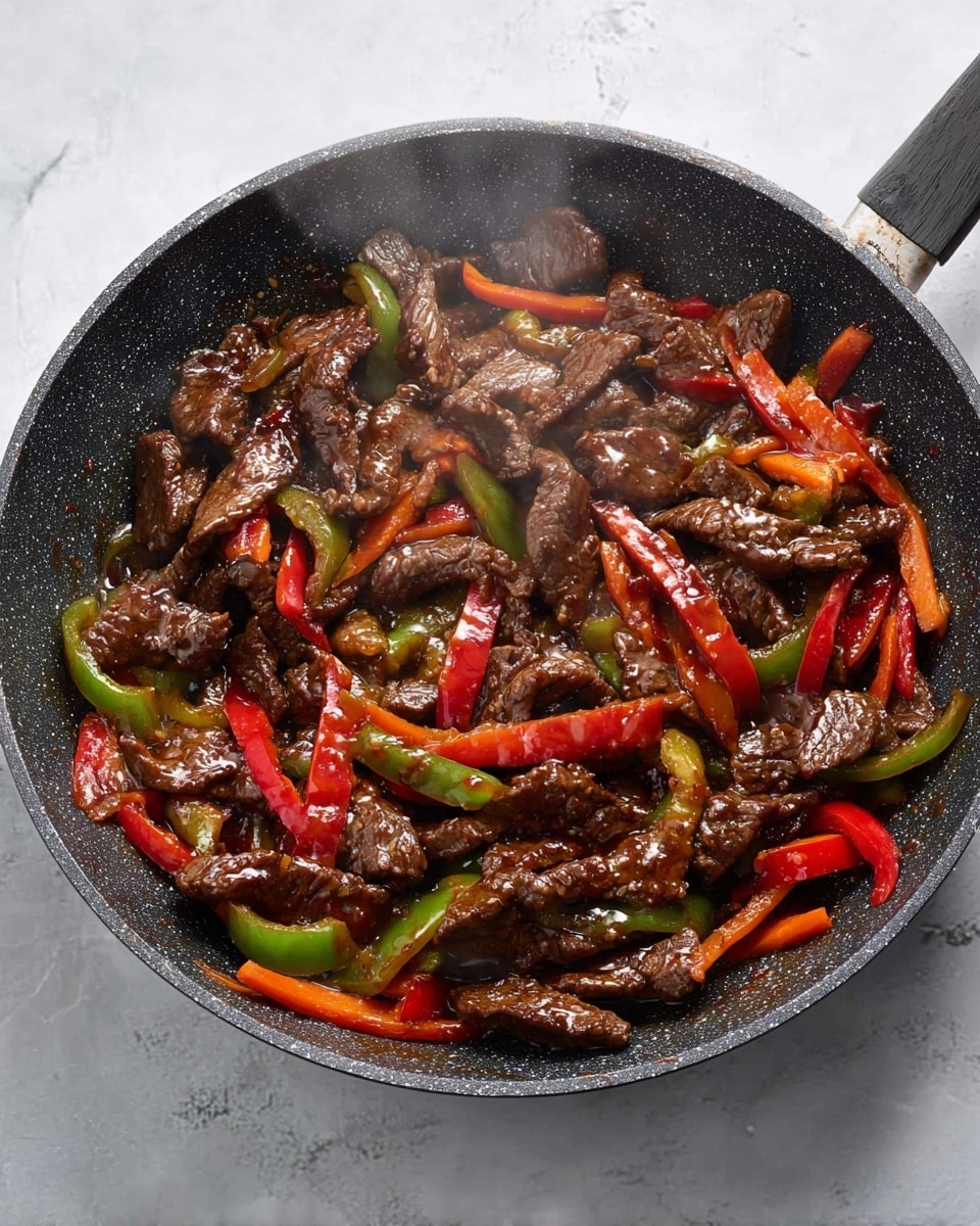 A black speckled frying pan filled with three main layers: tender dark brown beef strips cooked with a shiny glaze, bright red and green bell pepper slices, and orange carrot sticks, all mixed evenly. The beef has a glossy texture with slight char marks, while the peppers and carrots add fresh vibrant color and a slight crispness. Steam rises gently from the pan, placed on a white marbled surface. photo taken with an iphone --ar 4:5 --v 7