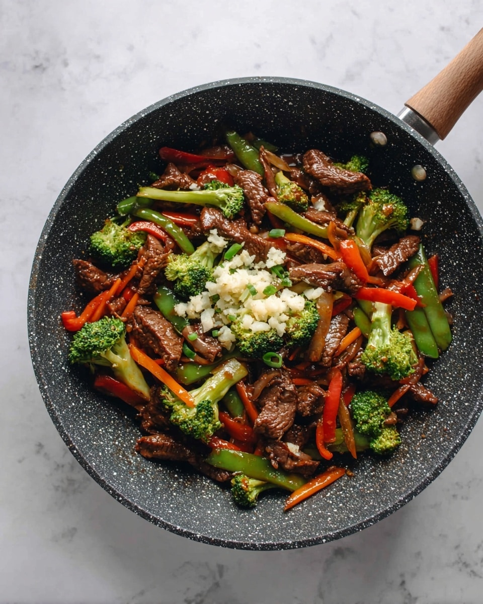 A black speckled frying pan on a white marbled surface holds a stir-fry with several layers: the base has thin brown beef strips mixed with shiny cooked carrot sticks and green and red bell pepper slices; bright green broccoli florets are scattered on top, adding a fresh texture; at the center, there is a small pile of finely chopped white garlic pieces; in the background, a woman's hand is seen holding the pan handle. photo taken with an iphone --ar 4:5 --v 7