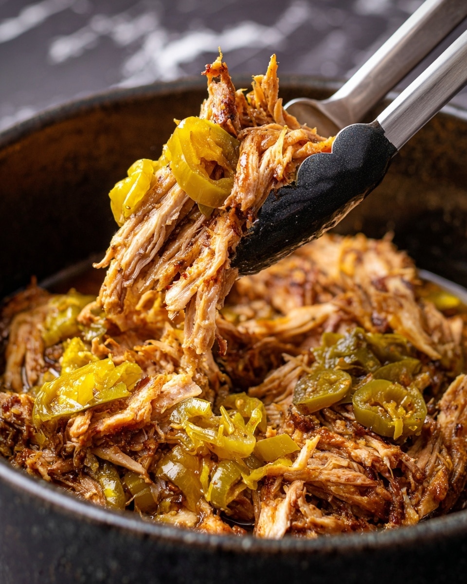 A pulled pork sandwich sits on a white plate with a shiny, light brown bun on top. Inside the sandwich, there is a thick layer of shredded pork in light brown color, topped with melted white and yellow cheese that drapes over the pork. On the side of the plate, there are light yellow crunchy potato chips and two greenish-yellow pepperoncini peppers. In the background, a white bowl filled with potato chips and a silver crockpot are visible, all set on a white marbled surface. photo taken with an iphone --ar 4:5 --v 7