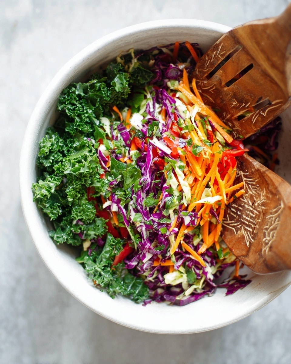 A white bowl filled with a colorful mixed salad shows five visible layers: deep green curly kale leaves, thin orange carrot strips, purple cabbage pieces, small white cabbage shreds, and thin red bell pepper slices, all layered together with small green herb bits sprinkled throughout; a large wooden salad hand with carved patterns is partially inside the bowl, mixing the salad, and the bowl is placed on a white marbled surface. photo taken with an iphone --ar 4:5 --v 7
