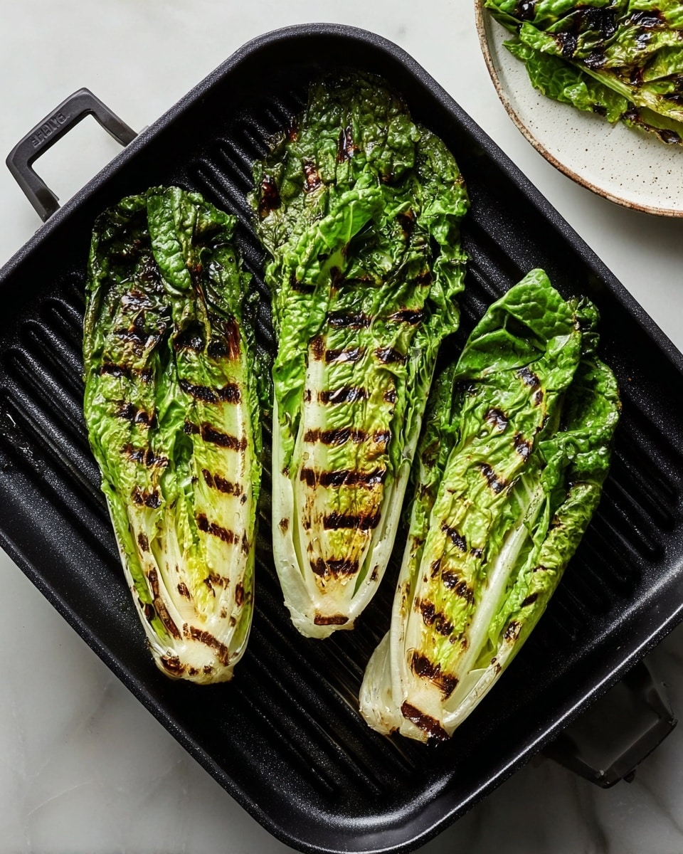 The image shows three long leaves of grilled romaine lettuce on a black grill pan, each leaf having visible dark brown grill marks in a crisscross pattern, with parts of the leaves showing bright green and light yellow colors. The grill pan is placed on a white marbled surface, and in the upper right corner, there is part of a white plate holding another grilled romaine leaf that is darker green with charred edges. Photo taken with an iphone --ar 4:5 --v 7