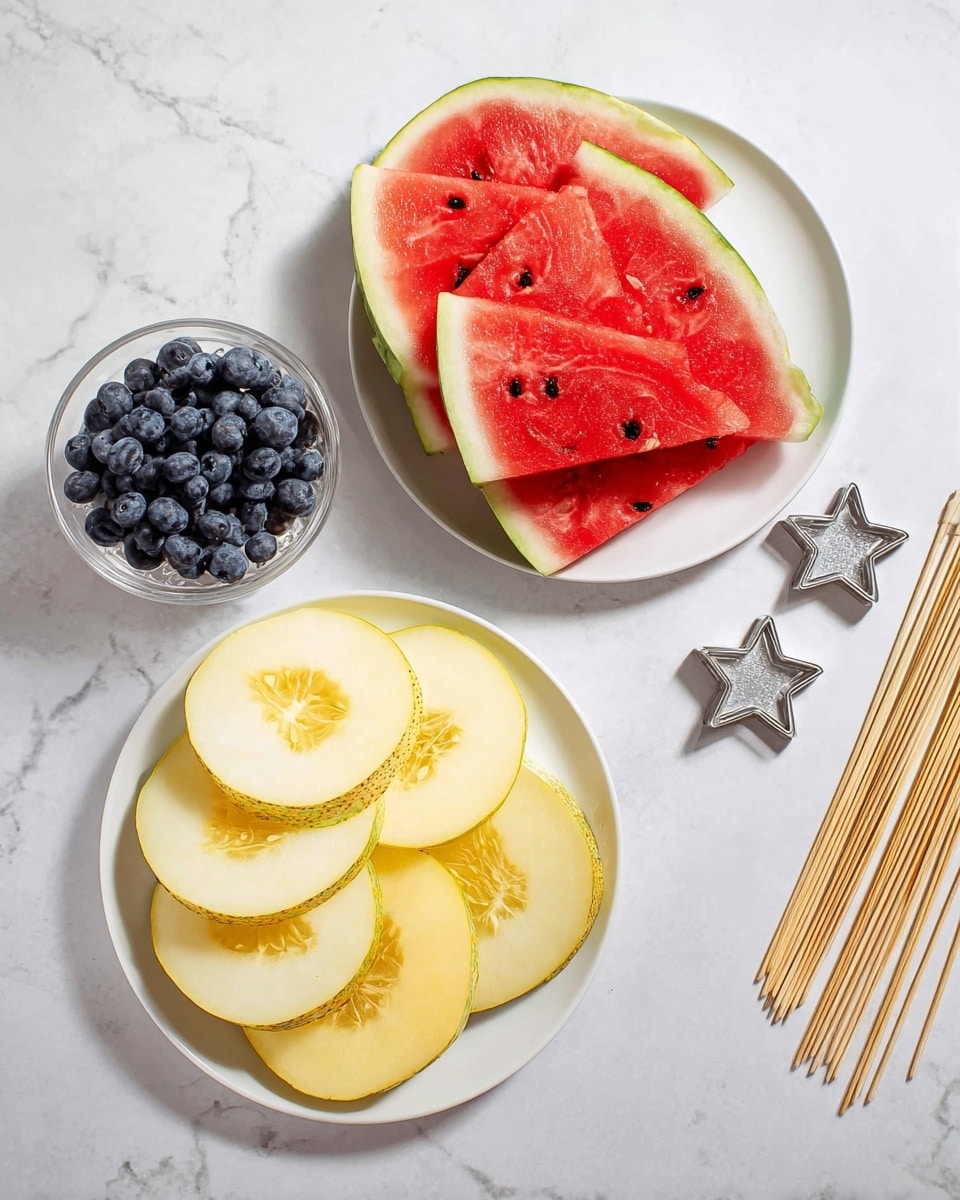 There are two white plates with fruit slices and a clear glass bowl with blueberries on a white marbled surface. The top plate holds four bright red watermelon slices with green edges arranged in layers. The plate below has six pale yellow melon slices with a visible seed section in the middle, arranged in a circular layer. To the right of the plates, there is a stack of wooden skewers pointing diagonally upward, and two small silver star-shaped cookie cutters placed near the plates. Photo taken with an iphone --ar 4:5 --v 7