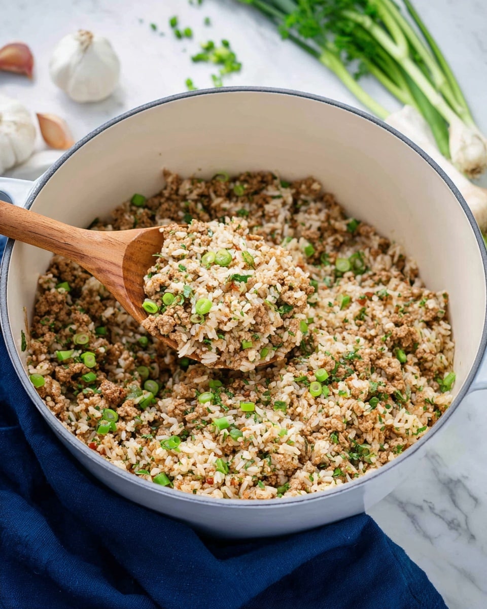 A close-up of cooked rice mixed with ground meat and chopped green herbs, all blended together with small pieces of green onions scattered throughout. This mixture fills a white pot that sits on a white marbled surface, with a wooden spoon lifting a portion of the rice and meat mix. In the background are some whole garlic, green onions, and fresh herbs, giving a fresh and natural look to the scene. A navy blue cloth is partially visible under the pot. photo taken with an iphone --ar 4:5 --v 7
