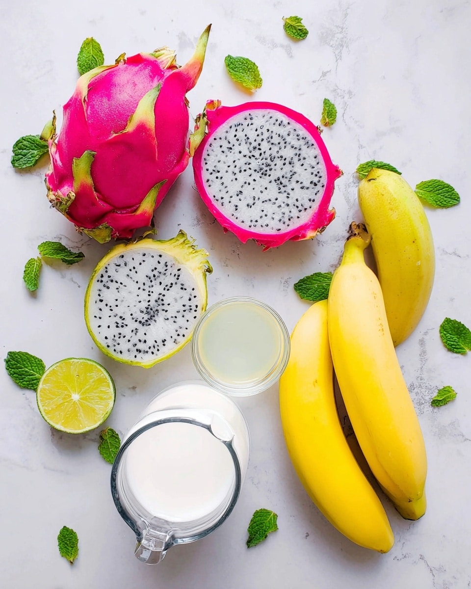 A top view of fresh fruits and ingredients placed on a white marbled surface, showing a whole bright pink dragon fruit at the top left with two halves of dragon fruit revealing white flesh with black seeds scattered inside; a half cut lime with pale green and white tones near the center; a small clear glass bowl with a light yellow liquid beside the lime; three yellow bananas placed on the right; a white pitcher filled with white liquid at the bottom center; and fresh green mint leaves scattered around the fruits and containers, maintaining a bright and fresh look with natural shadows; photo taken with an iphone --ar 4:5 --v 7