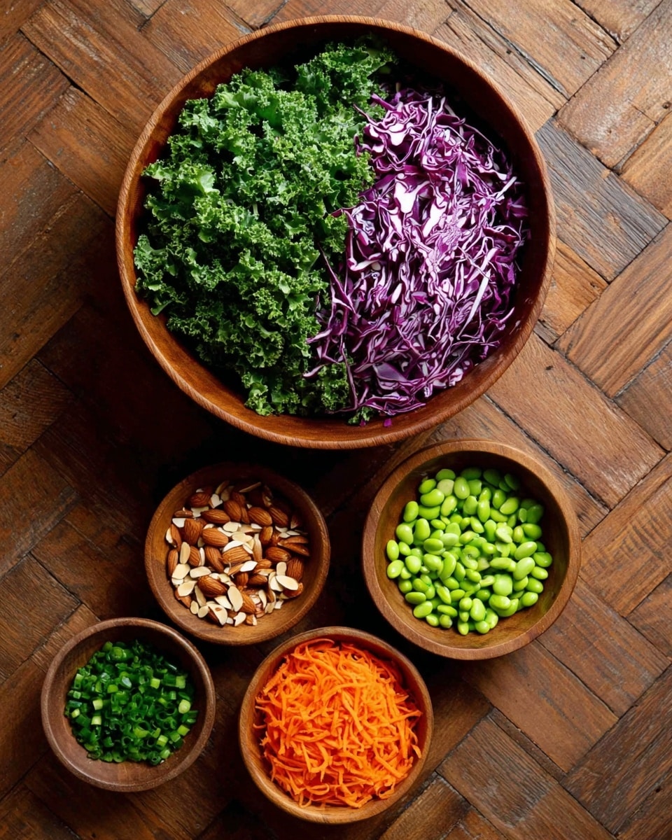 A large wooden bowl contains two layers: the left side is filled with bright green curly kale leaves, and the right side holds thin slices of vibrant purple cabbage with white veins. Surrounding this main bowl are smaller wooden bowls, each with a different ingredient: at the top right is a bowl full of green edamame beans, below it is a bowl of chopped brown almonds, at the bottom right are thin orange carrot sticks, and at the bottom left is a bowl of chopped green onions. All bowls sit on a wooden surface with a herringbone pattern. photo taken with an iphone --ar 4:5 --v 7