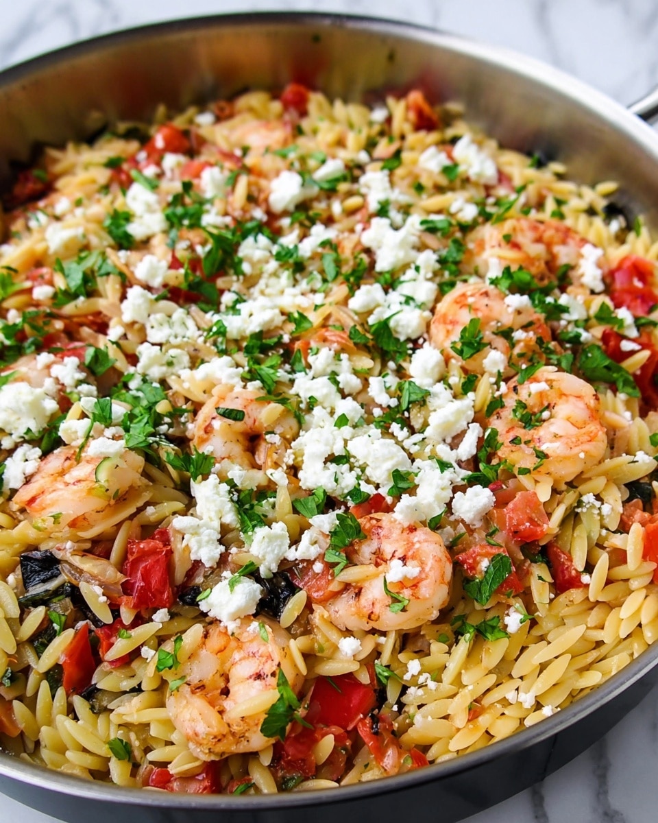 The image shows a close-up of a pan filled with a colorful pasta dish. The bottom layer is a bed of small, light yellow orzo pasta scattered across the pan. Mixed within the pasta are pieces of cooked shrimp that have a soft pink color. On top of the pasta and shrimp are bright red chunks of tomato and dark green pieces of leafy herbs. A layer of white crumbled cheese is spread evenly over the top, adding texture and contrast. Small bits of green parsley are sprinkled over the entire dish, giving it a fresh, vibrant look. The pan sits on a white marbled surface. photo taken with an iphone --ar 4:5 --v 7