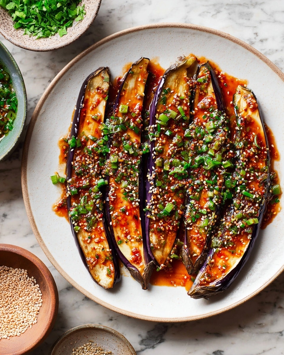 The dish shows six long, thin slices of eggplant arranged side by side on a white plate. Each eggplant slice has a dark purple skin around the edges and a light creamy inside. They are covered in a shiny, reddish-brown sauce sprinkled with small white sesame seeds and small, bright green pieces of chopped herbs scattered on top. The plate sits on a white marbled surface with a small bowl of green herbs and a small bowl of sesame seeds placed nearby. The scene looks fresh and vibrant. photo taken with an iphone --ar 4:5 --v 7